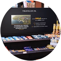 ekran nad regałem produktowym na stacji benzynowej